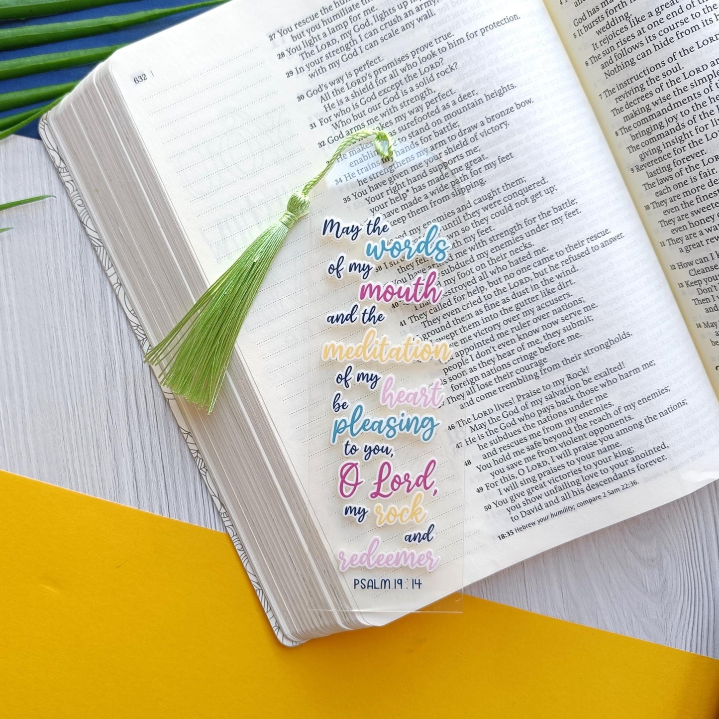 Open book with colorful text and tassel bookmark on a yellow and white background