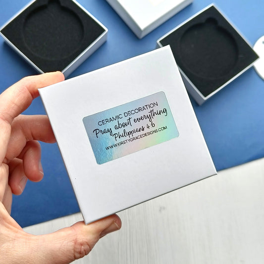 Ceramic decoration packaging with a hand holding the box on a blue background