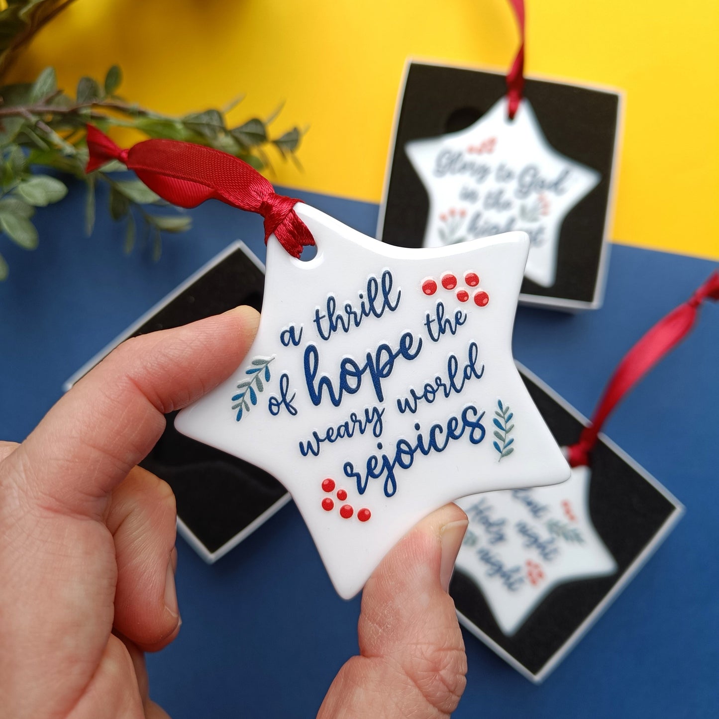 Star-shaped ornament with motivational quote held by a hand against a colorful background