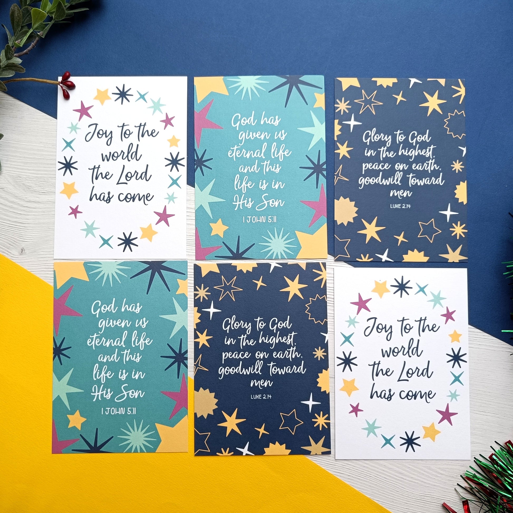 Set of six colorful cards with star designs and religious text on a blue and yellow background.